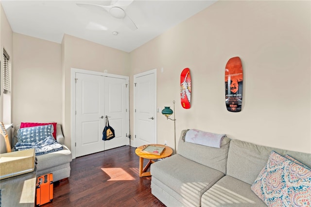 living room featuring dark wood-type flooring and ceiling fan