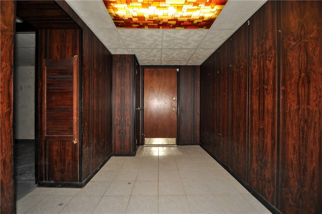 hallway featuring wood walls