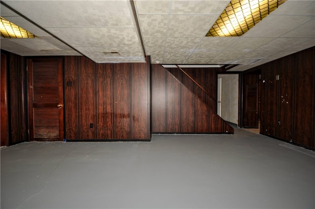 basement featuring wood walls