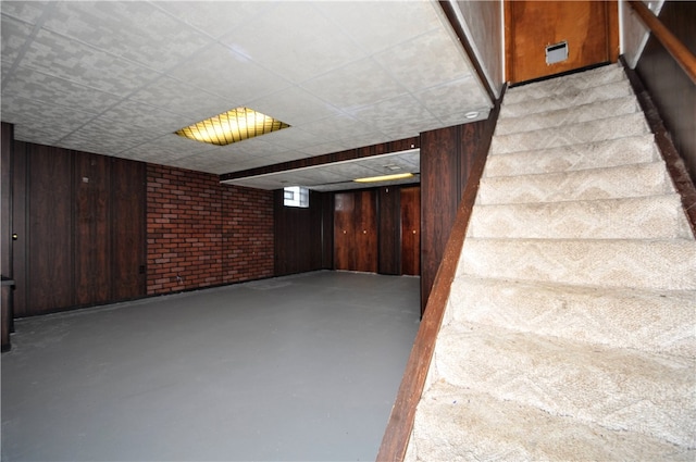 basement featuring wooden walls