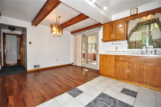 kitchen with light hardwood / wood-style floors, an inviting chandelier, sink, beam ceiling, and decorative light fixtures