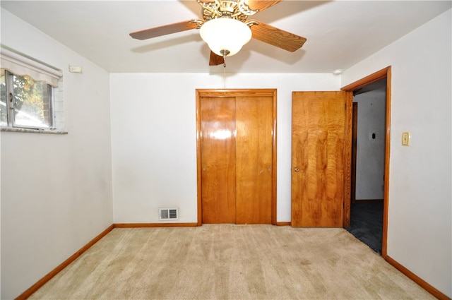 unfurnished bedroom featuring ceiling fan and light colored carpet