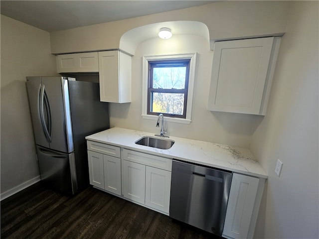 kitchen with dark wood-type flooring, white cabinetry, appliances with stainless steel finishes, and sink