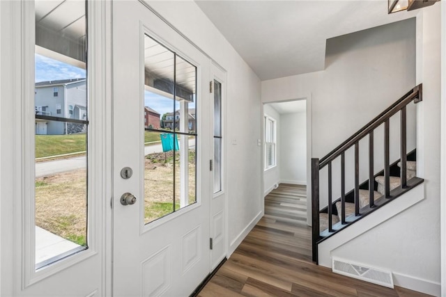 entrance foyer with plenty of natural light and dark hardwood / wood-style floors