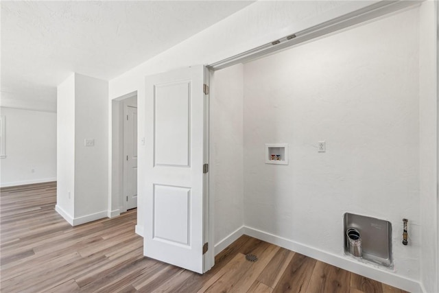 washroom with hookup for a washing machine and light hardwood / wood-style flooring