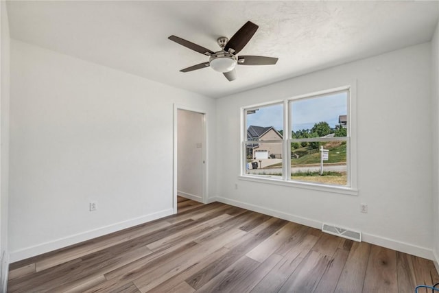 spare room featuring light hardwood / wood-style floors and ceiling fan