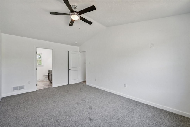 unfurnished bedroom with carpet, ensuite bathroom, ceiling fan, and lofted ceiling