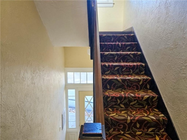 staircase featuring a textured wall