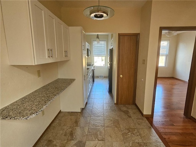 hall with healthy amount of natural light and baseboards