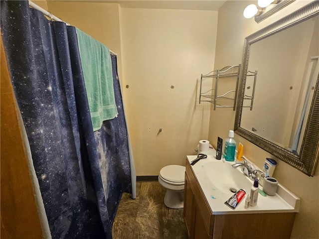 bathroom featuring toilet, baseboards, a shower with shower curtain, and vanity