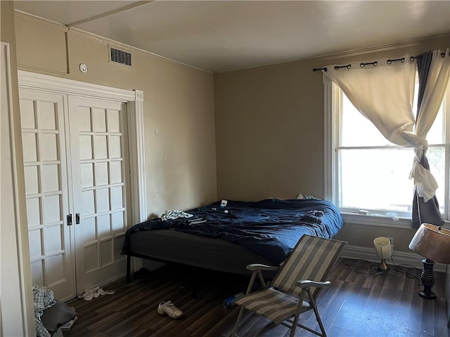 bedroom with dark hardwood / wood-style flooring