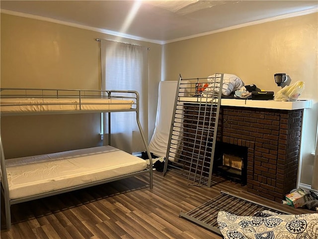 bedroom with hardwood / wood-style floors, a brick fireplace, and crown molding