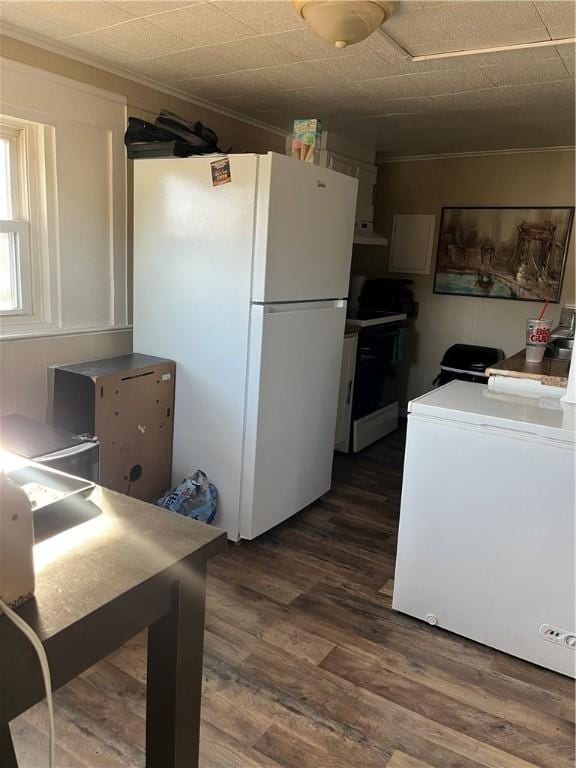 kitchen with white cabinets, dark hardwood / wood-style flooring, white appliances, and ornamental molding