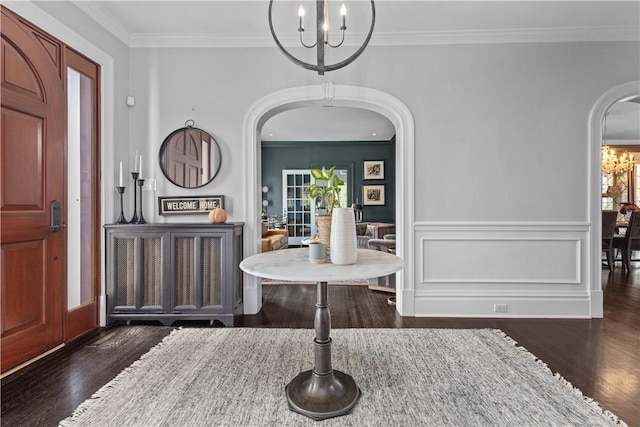 entryway featuring crown molding, dark wood-type flooring, and a chandelier