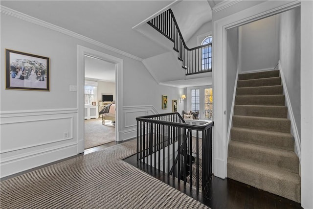 stairway with hardwood / wood-style flooring, crown molding, and a wealth of natural light