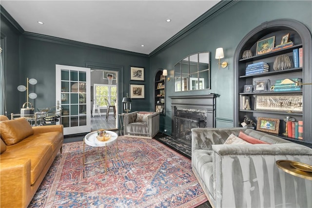 living room featuring crown molding, built in features, and hardwood / wood-style flooring