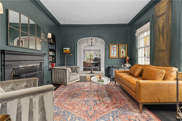 sitting room with plenty of natural light, a fireplace, dark hardwood / wood-style flooring, and crown molding