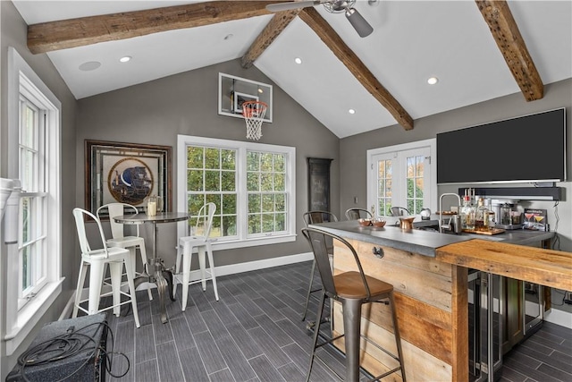 bar with beam ceiling, ceiling fan, and high vaulted ceiling