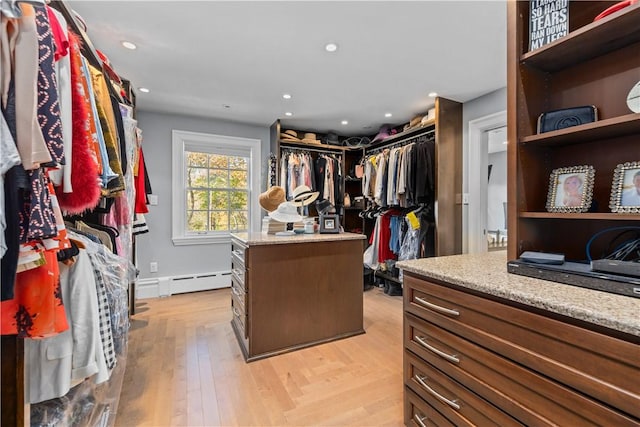 walk in closet featuring light hardwood / wood-style flooring and a baseboard heating unit