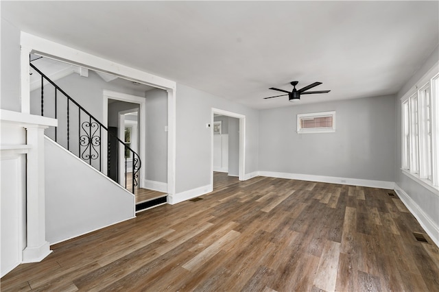 unfurnished living room with dark hardwood / wood-style flooring and ceiling fan