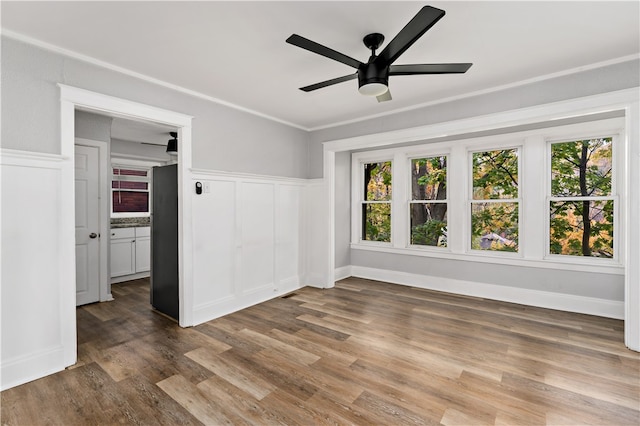 interior space featuring ornamental molding, plenty of natural light, wood-type flooring, and ceiling fan