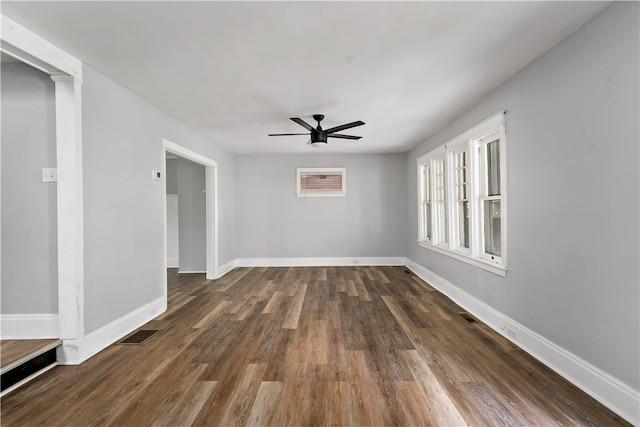 unfurnished room with ceiling fan, dark hardwood / wood-style floors, and decorative columns