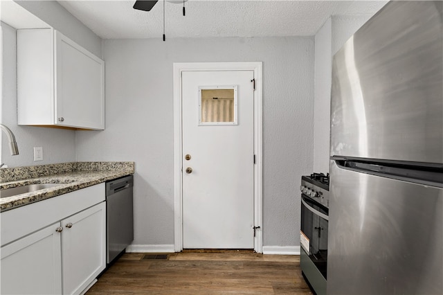 kitchen with white cabinets, dark hardwood / wood-style flooring, sink, and appliances with stainless steel finishes