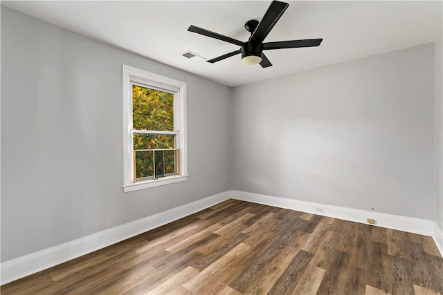 spare room with dark hardwood / wood-style flooring and ceiling fan