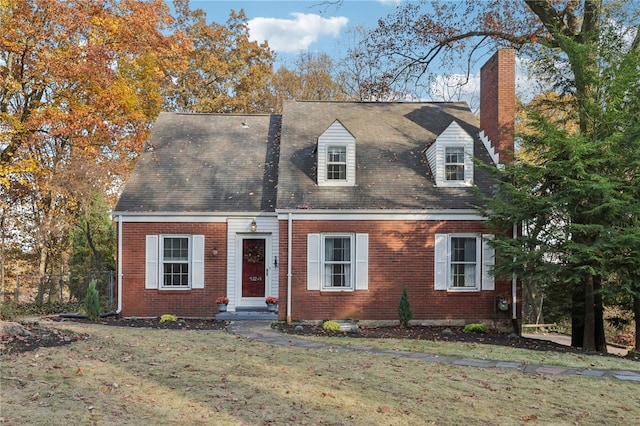 cape cod home with a front yard