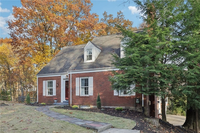 cape cod-style house with a front lawn