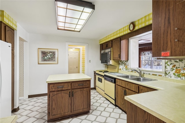 kitchen featuring a center island, white appliances, and sink