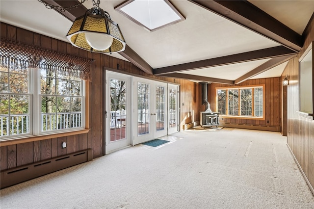 unfurnished sunroom with baseboard heating, a wood stove, french doors, and vaulted ceiling with beams