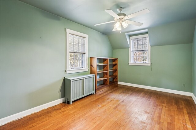 additional living space featuring radiator, ceiling fan, vaulted ceiling, and light wood-type flooring