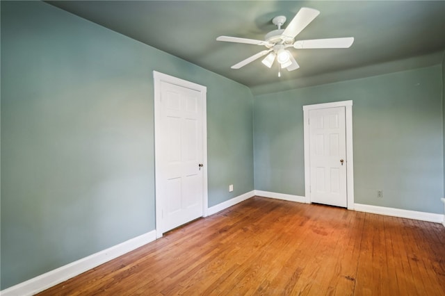 empty room with ceiling fan and hardwood / wood-style flooring