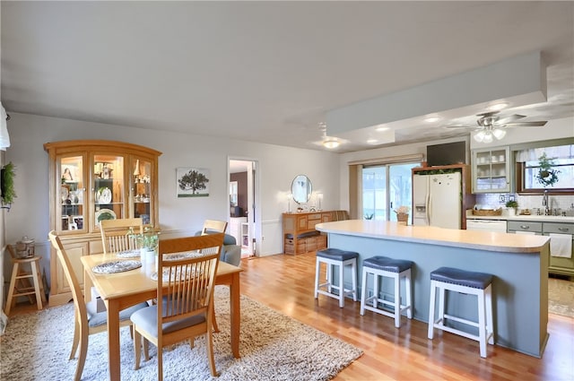 dining area featuring light hardwood / wood-style flooring, ceiling fan, and sink