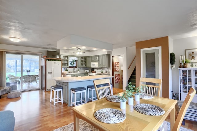 dining space featuring light hardwood / wood-style flooring, ceiling fan, and sink