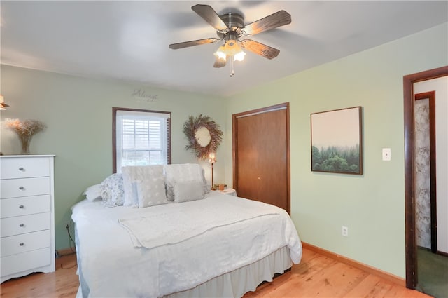 bedroom featuring a closet, light hardwood / wood-style flooring, and ceiling fan