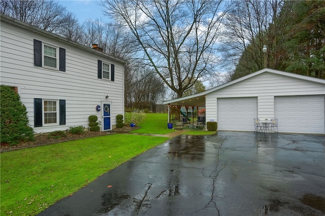 view of side of property featuring a lawn, a garage, and a carport