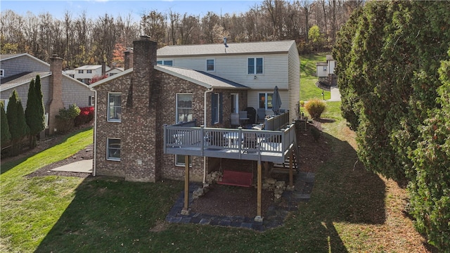 back of property with a deck and a lawn