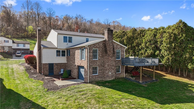 rear view of house featuring a wooden deck and a yard