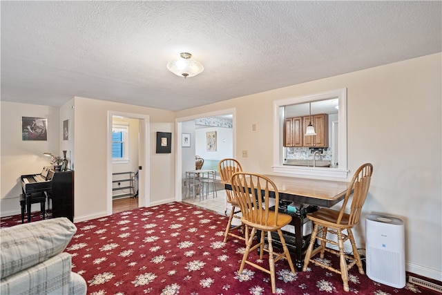 dining room featuring a textured ceiling and carpet floors