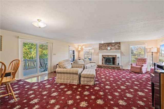 living room featuring a textured ceiling and a brick fireplace