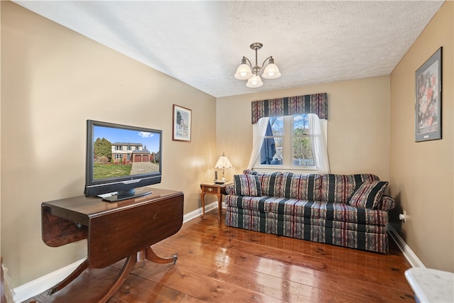 living room with hardwood / wood-style floors, a notable chandelier, and a textured ceiling