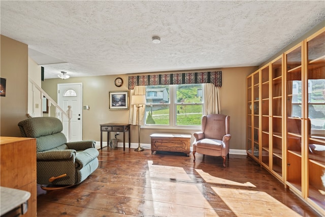 living area with a textured ceiling and hardwood / wood-style flooring