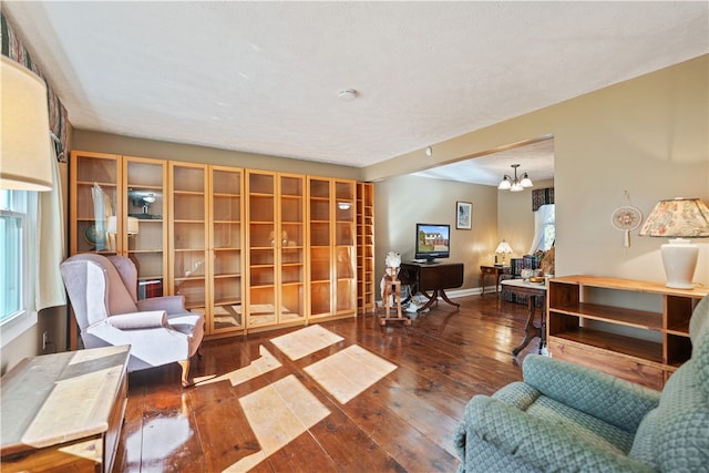 living room featuring dark hardwood / wood-style flooring and an inviting chandelier