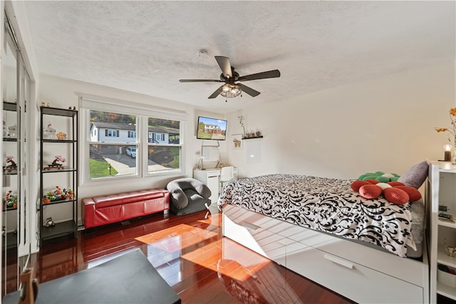 bedroom featuring hardwood / wood-style flooring, ceiling fan, and a textured ceiling