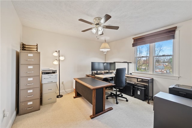 office space with a textured ceiling, light colored carpet, and ceiling fan