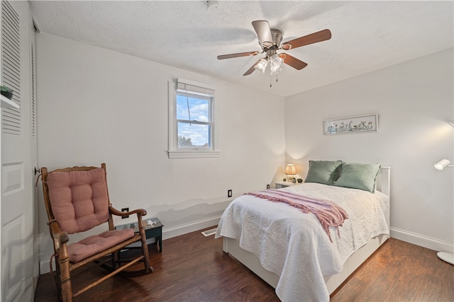 bedroom with ceiling fan, dark hardwood / wood-style flooring, and a textured ceiling