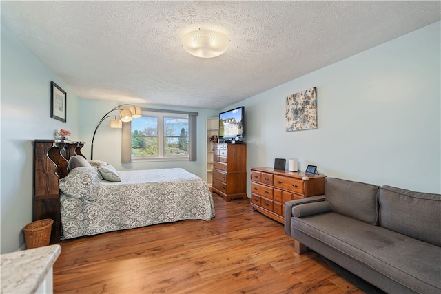 bedroom featuring a textured ceiling and hardwood / wood-style flooring