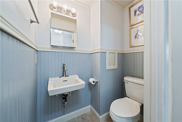 bathroom featuring crown molding, sink, and toilet